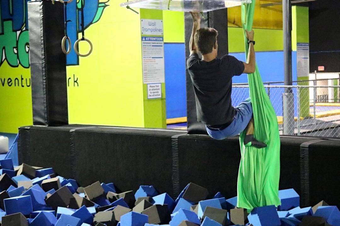 A man jumping on the side of a trampoline.